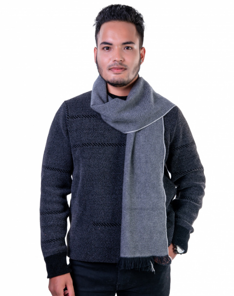 Man wearing a gray herringbone cashmere scarf, styled over a dark sweater, showcasing a versatile winter accessory.