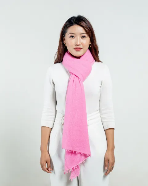 Woman styling a baby pink felted cashmere scarf.