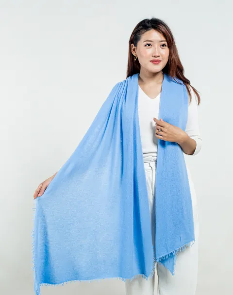 Elegant sky blue cashmere scarf draped to showcase fine craftsmanship and smooth texture.