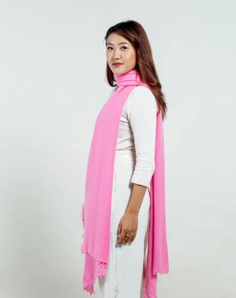 Side profile of a woman showcasing the length and texture of a pastel pink stole from Cashmere Kala, paired with a white outfit.