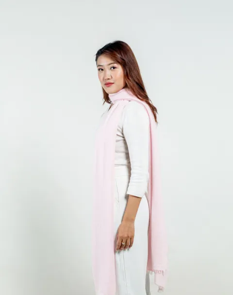 Model wearing light pink felted cashmere scarf highlighting its soft texture and quality craftsmanship.