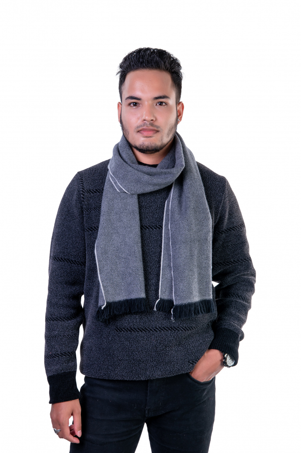 Man wearing a gray herringbone cashmere scarf with fringe, styled over a dark sweater, highlighting a winter look.